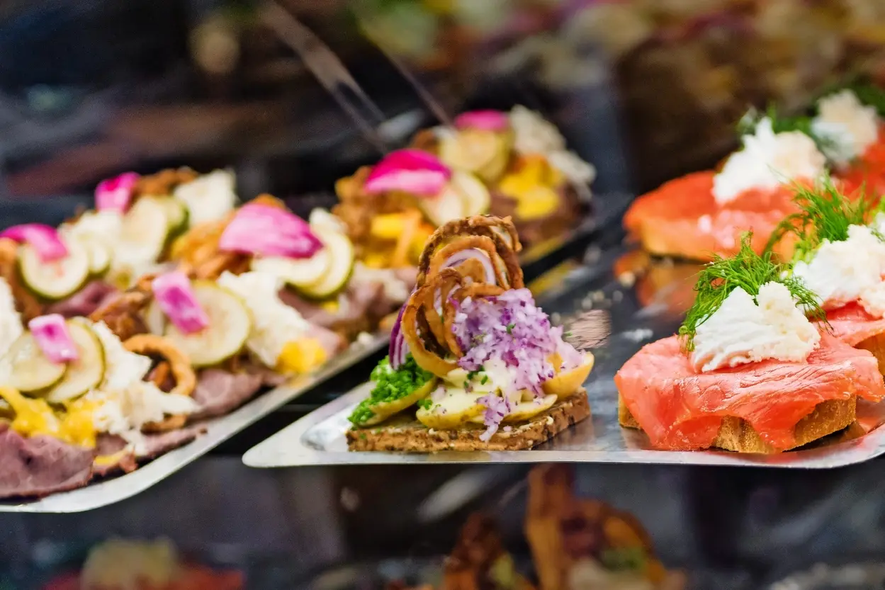 Display of assorted canapés, including salmon and vegetables.
