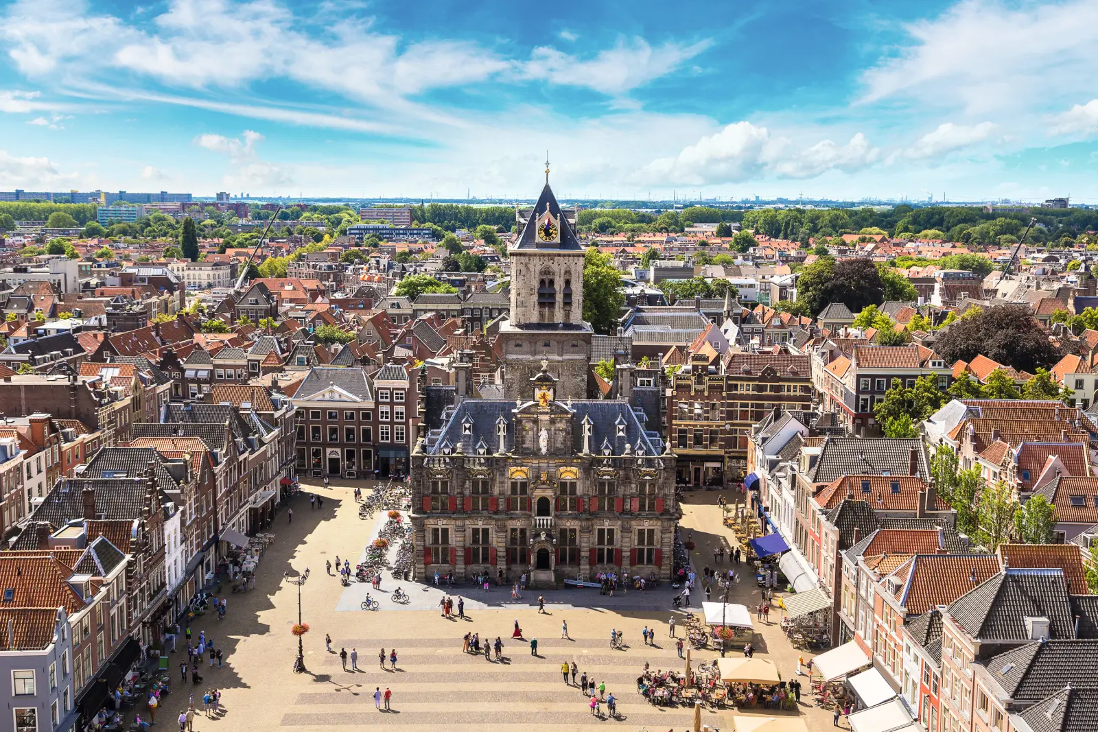 Aerial view of a central square in a town with a historic building and church tower.