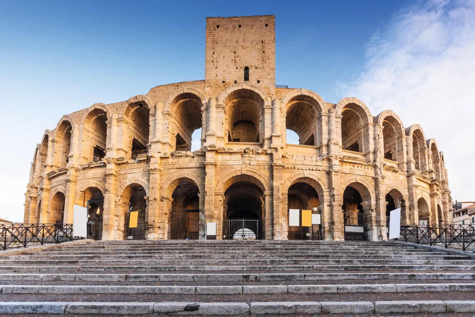 Anfiteatro romano con cielo azzurro, vista laterale dal basso.