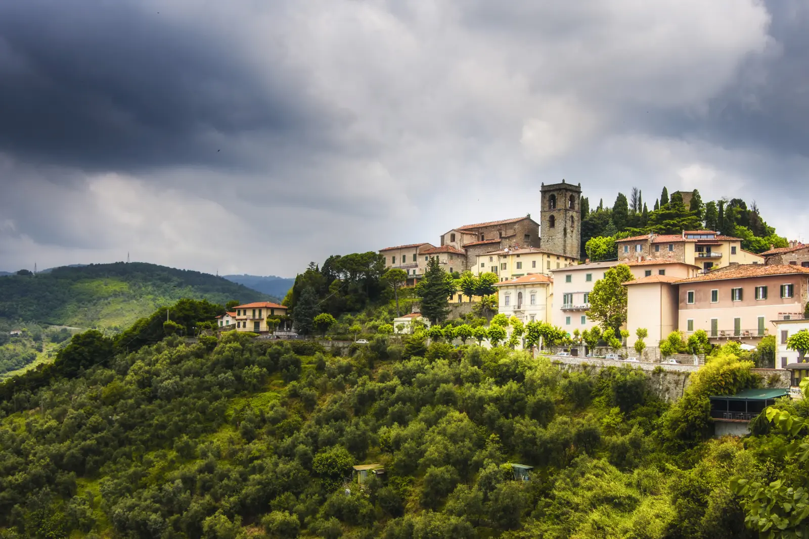 Montecatini Terme in der Toskana, umgeben von grünen Hügeln und bewölktem Himmel.