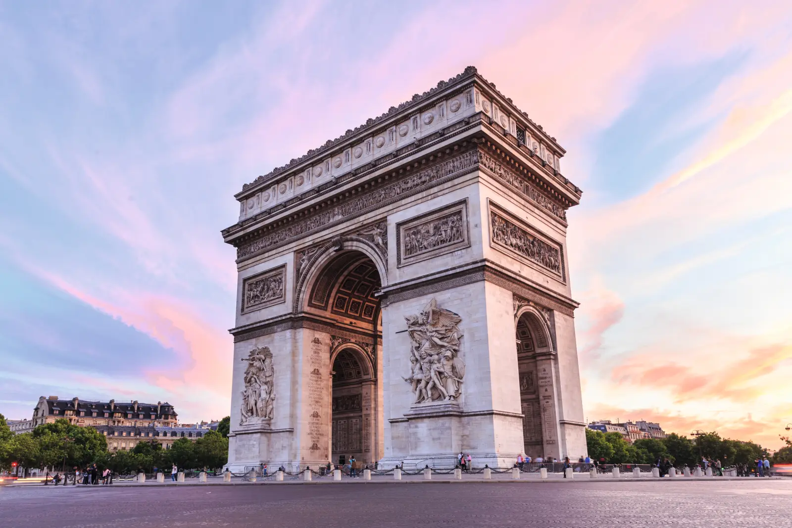 Arc de Triomphe in Paris at sunset, with a pink and blue sky.