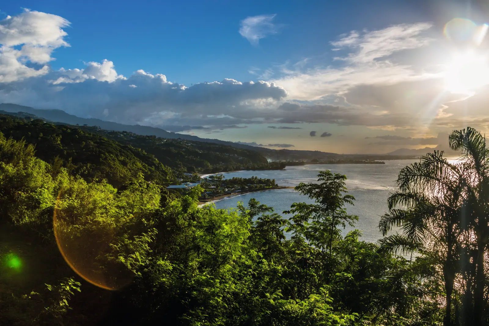 Küstenlandschaft mit felsigen Hügeln, Meer und Sonnenaufgang im Hintergrund.