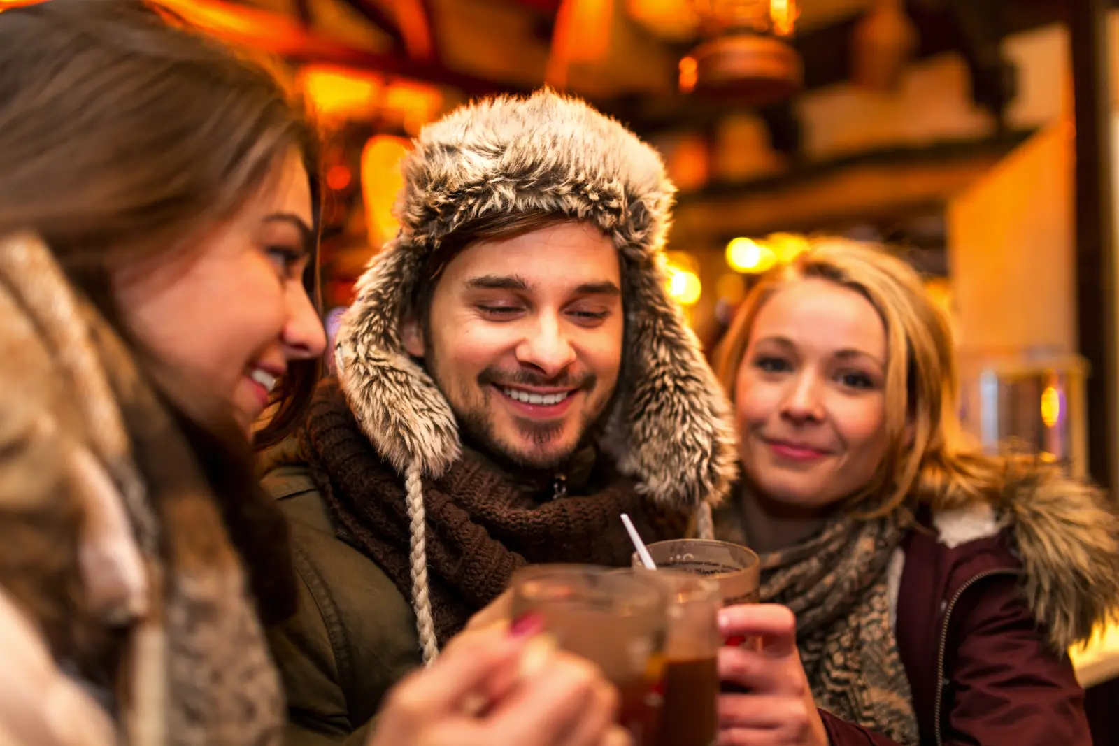 Amis buvant du vin chaud au marché de Noël
