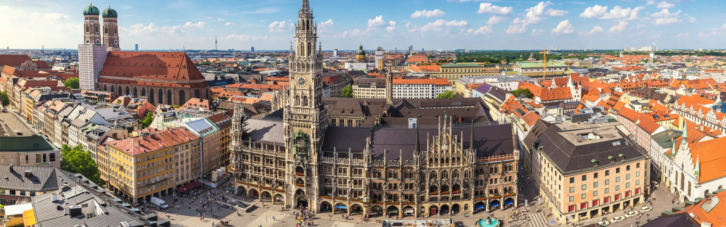Panoramic view of the busy Marienplatz in Munich in sunny weather.