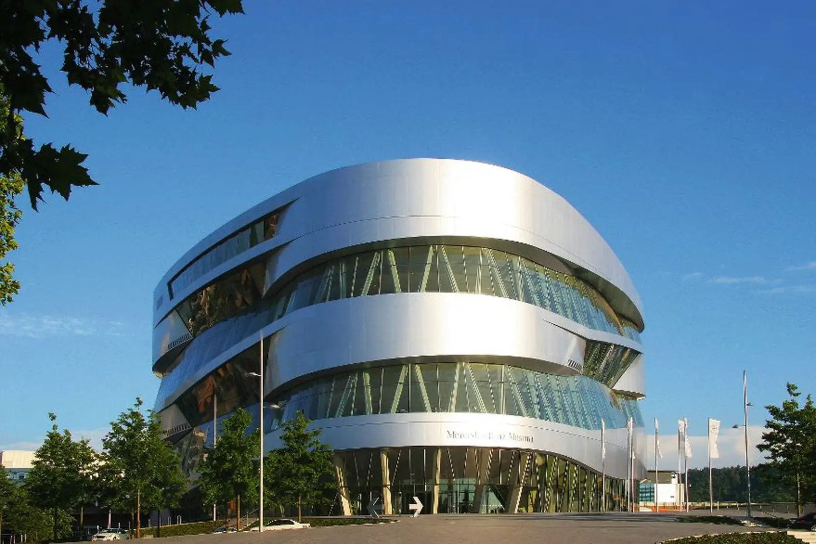 Edificio futuristico del Mercedes-Benz Museum sotto un cielo azzurro.