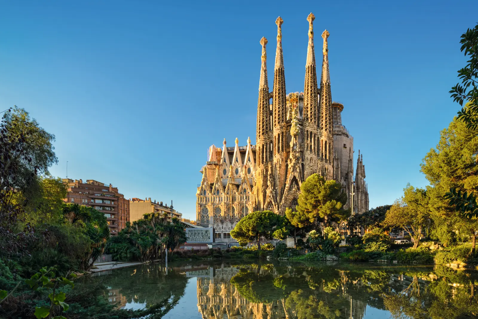 Cattedrale con alte torri e riflesso nell'acqua sotto un cielo sereno.