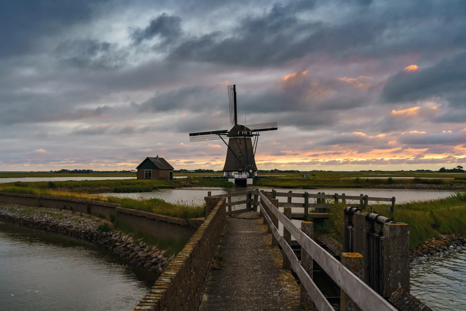Mulino a vento presso un piccolo lago al tramonto nelle Kagerplassen, Olanda Meridionale, Paesi Bassi.