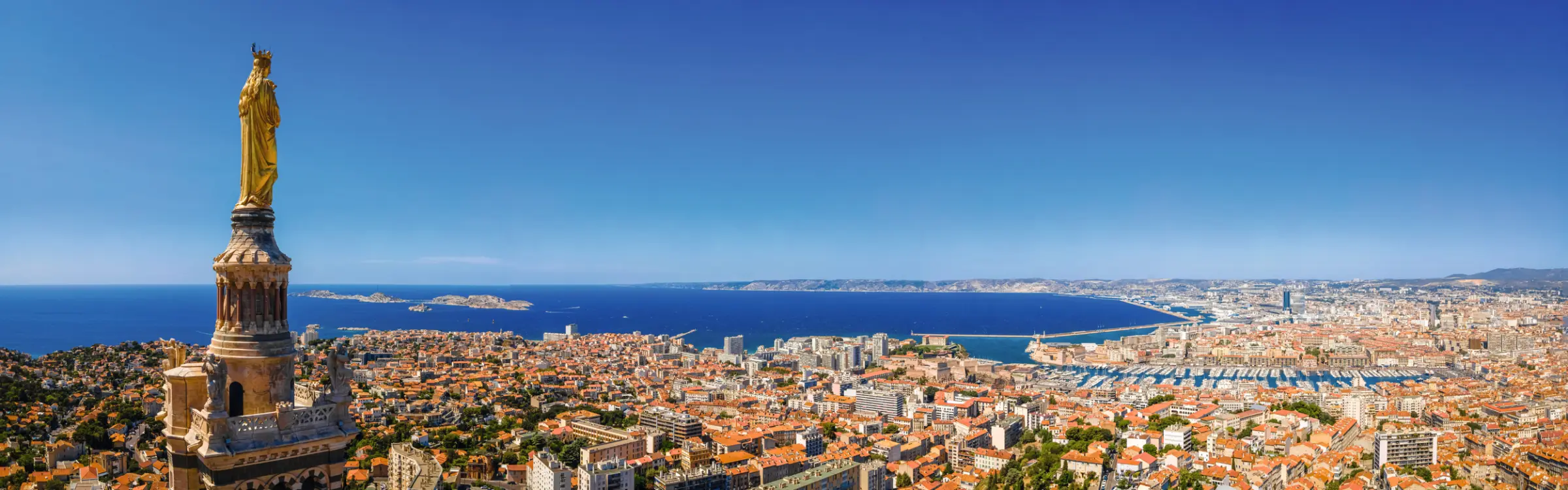 Vista su Marsiglia con Notre-Dame de la Garde e il Mediterraneo sullo sfondo.