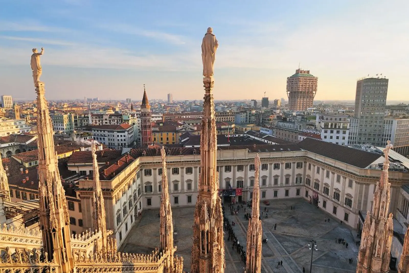 Vue de Milan avec sculptures et panorama urbain au coucher du soleil.