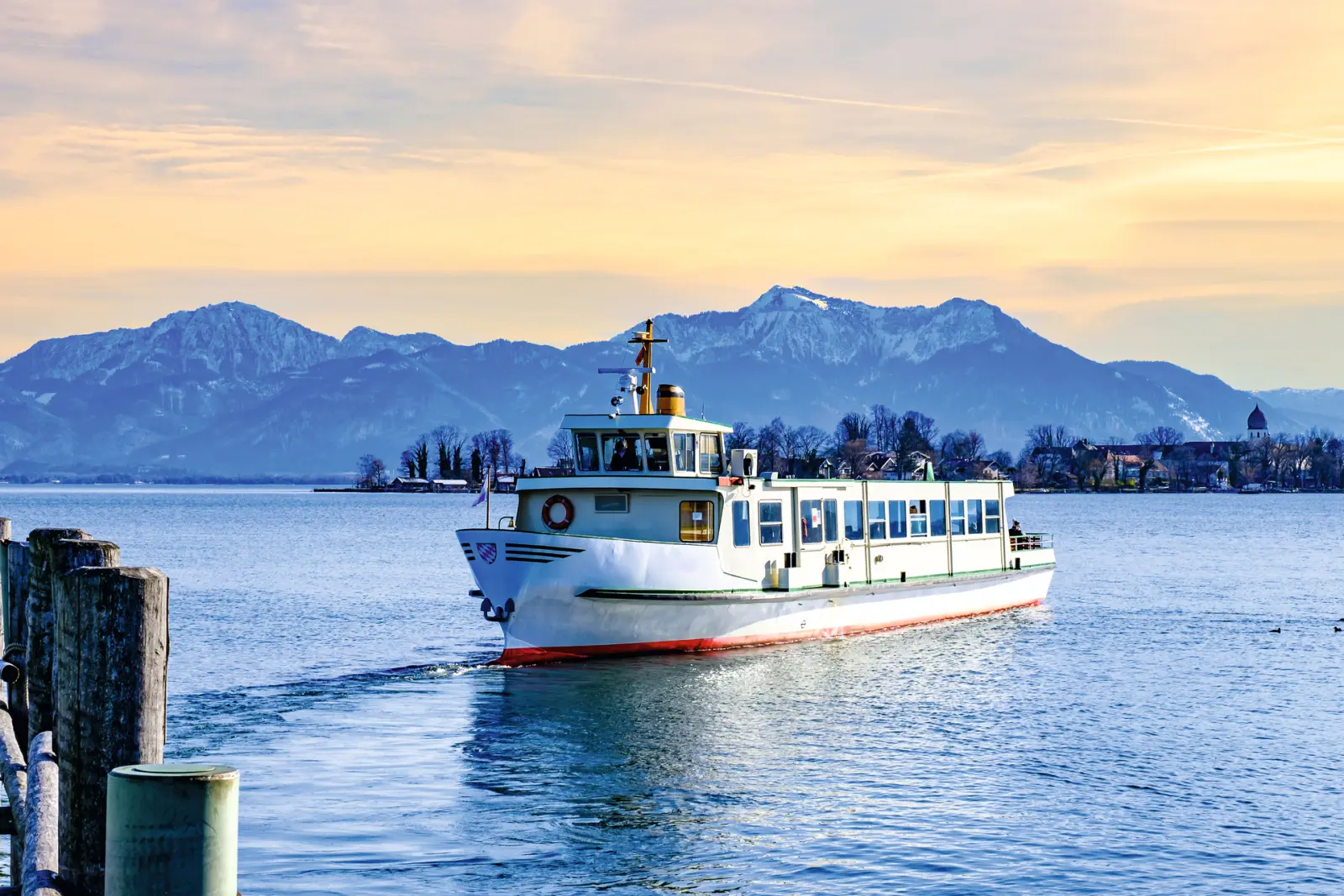 A boat on a lake with snow-covered mountains in the background.