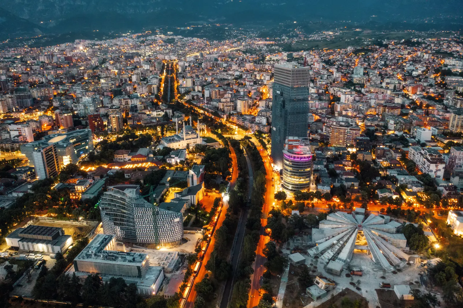 Skyline di Tirana, capitale dell'Albania, di notte con edifici illuminati nei Balcani.
