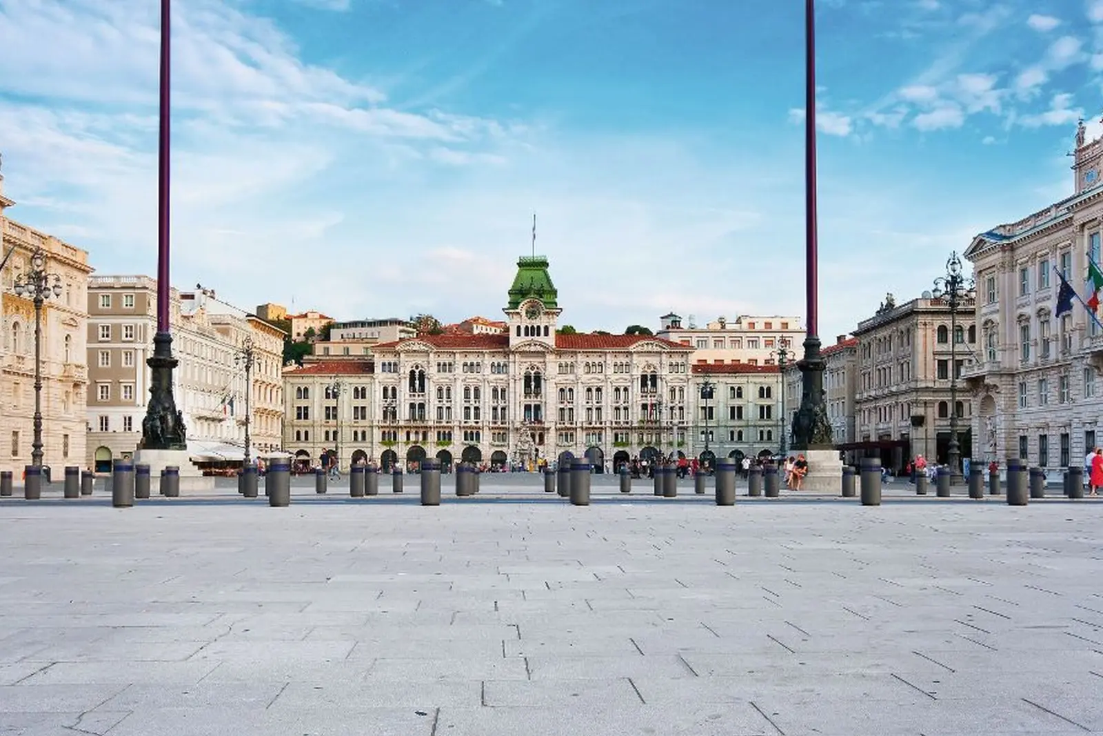 Piazza storica circondata da antichi edifici sotto un cielo azzurro.