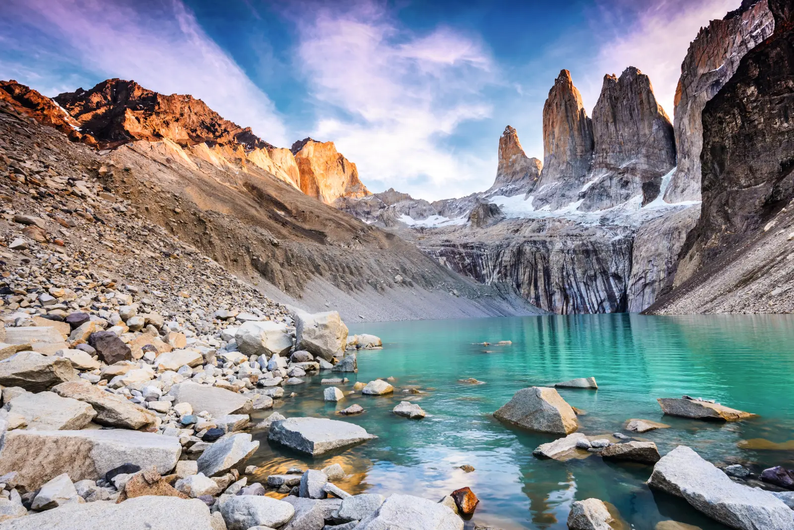 Vista di un lago di montagna turchese e formazioni rocciose all'alba in Patagonia