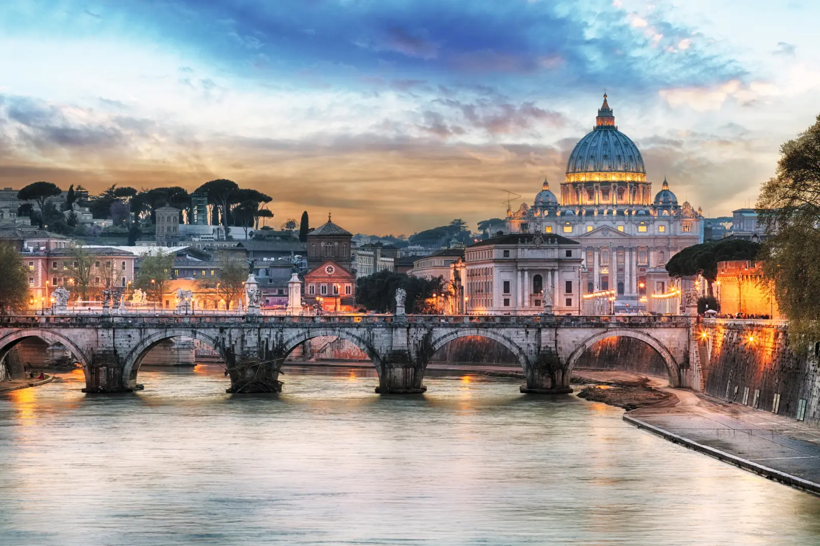 Basilica di San Pietro e ponte sul Tevere al tramonto a Roma.