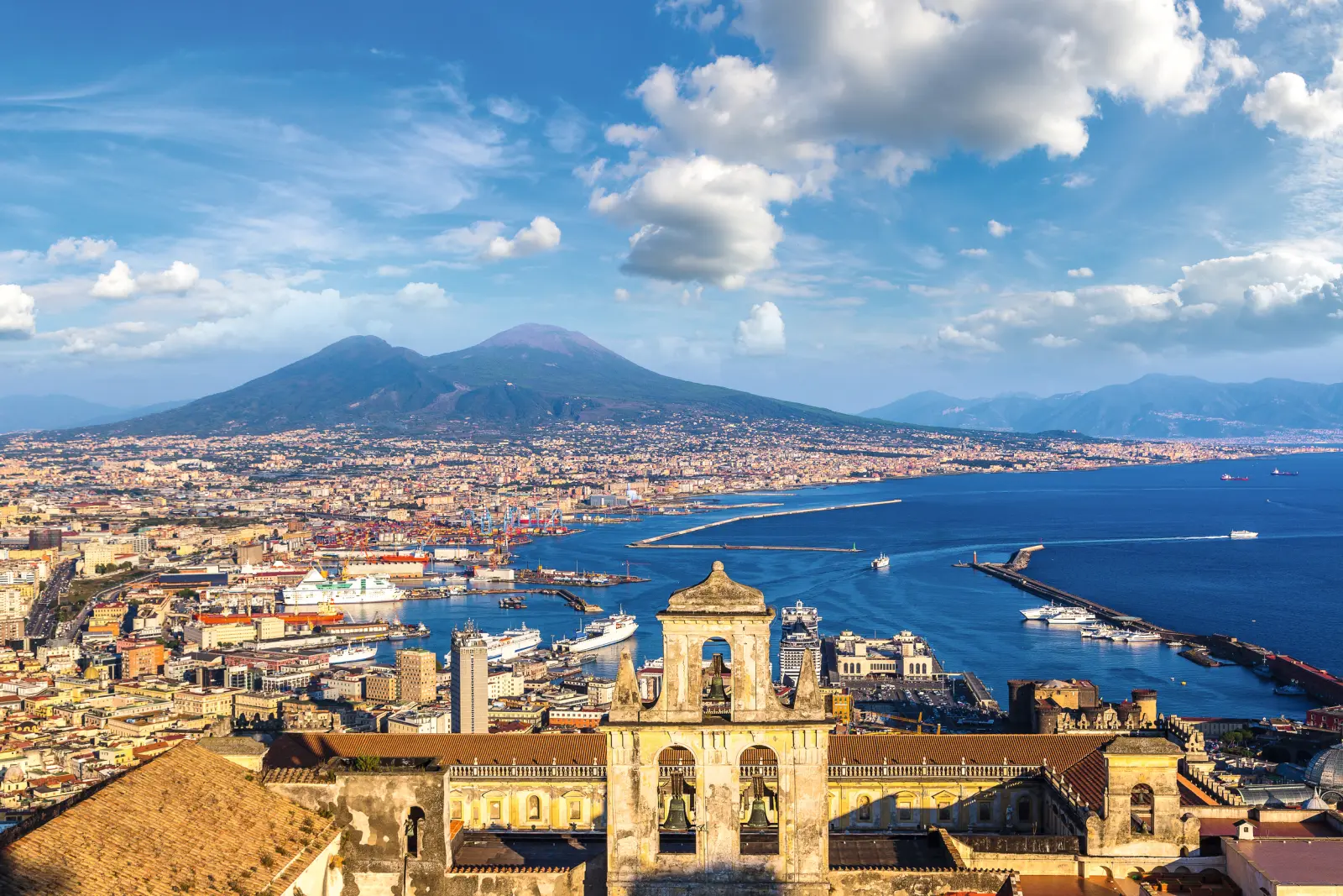 Panorama of Naples with Mount Vesuvius in the background and a view of the sea.