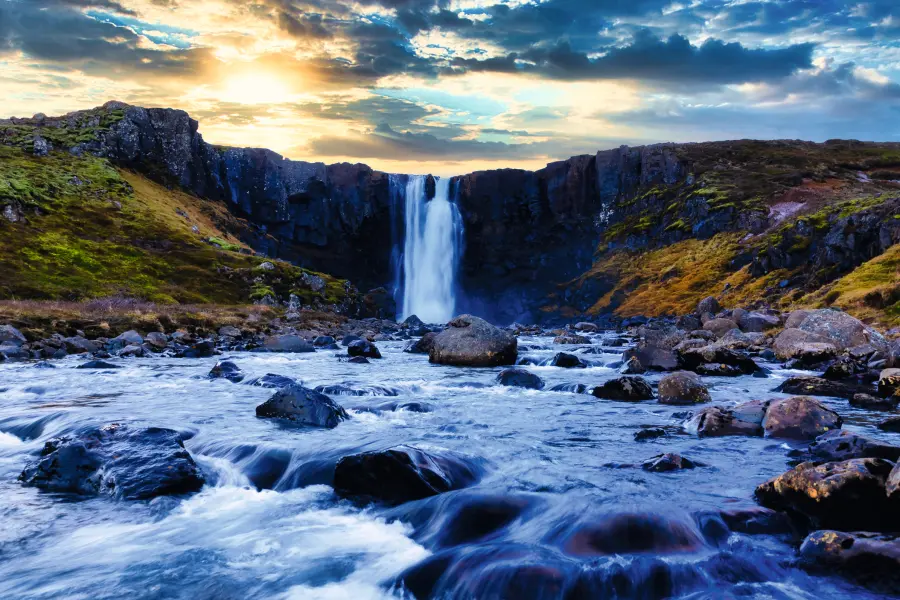 Cascata in un paesaggio roccioso al tramonto.