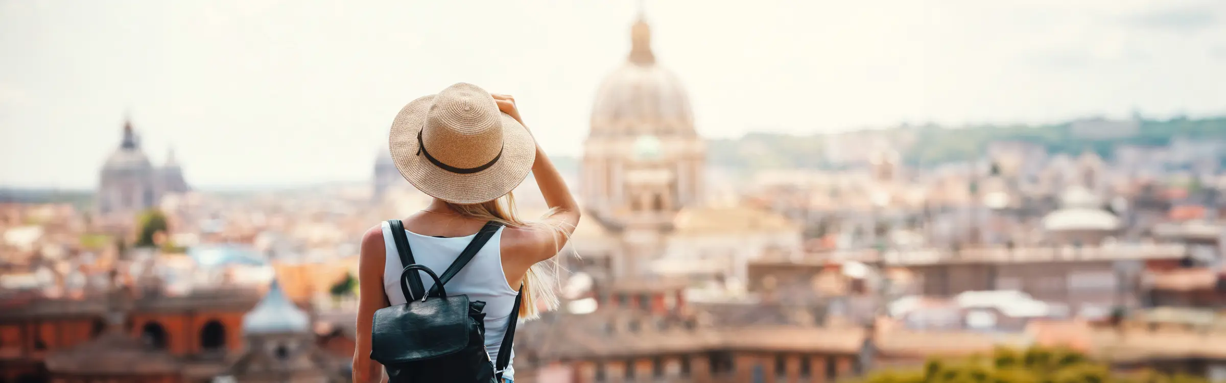 Una donna con cappello e zaino ammira lo skyline di Roma, capitale d'Italia.