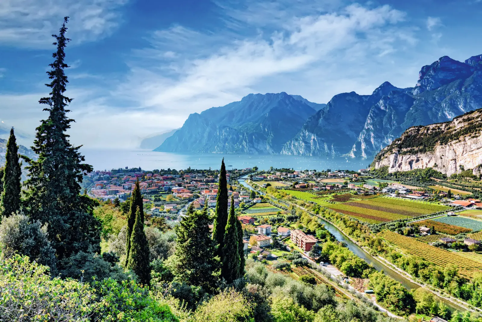 View of Lake Garda with the towns of Torbole, Arco and Riva del Garda surrounded by the Alps.