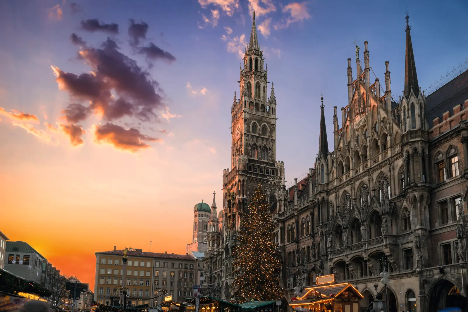 New Town Hall in Munich at sunset with Christmas tree and market stalls.