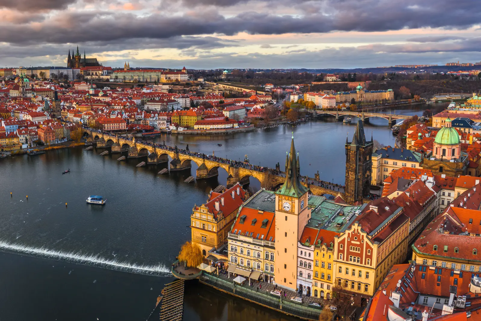 Vista del Ponte Carlo e della città di Praga con cielo nuvoloso.