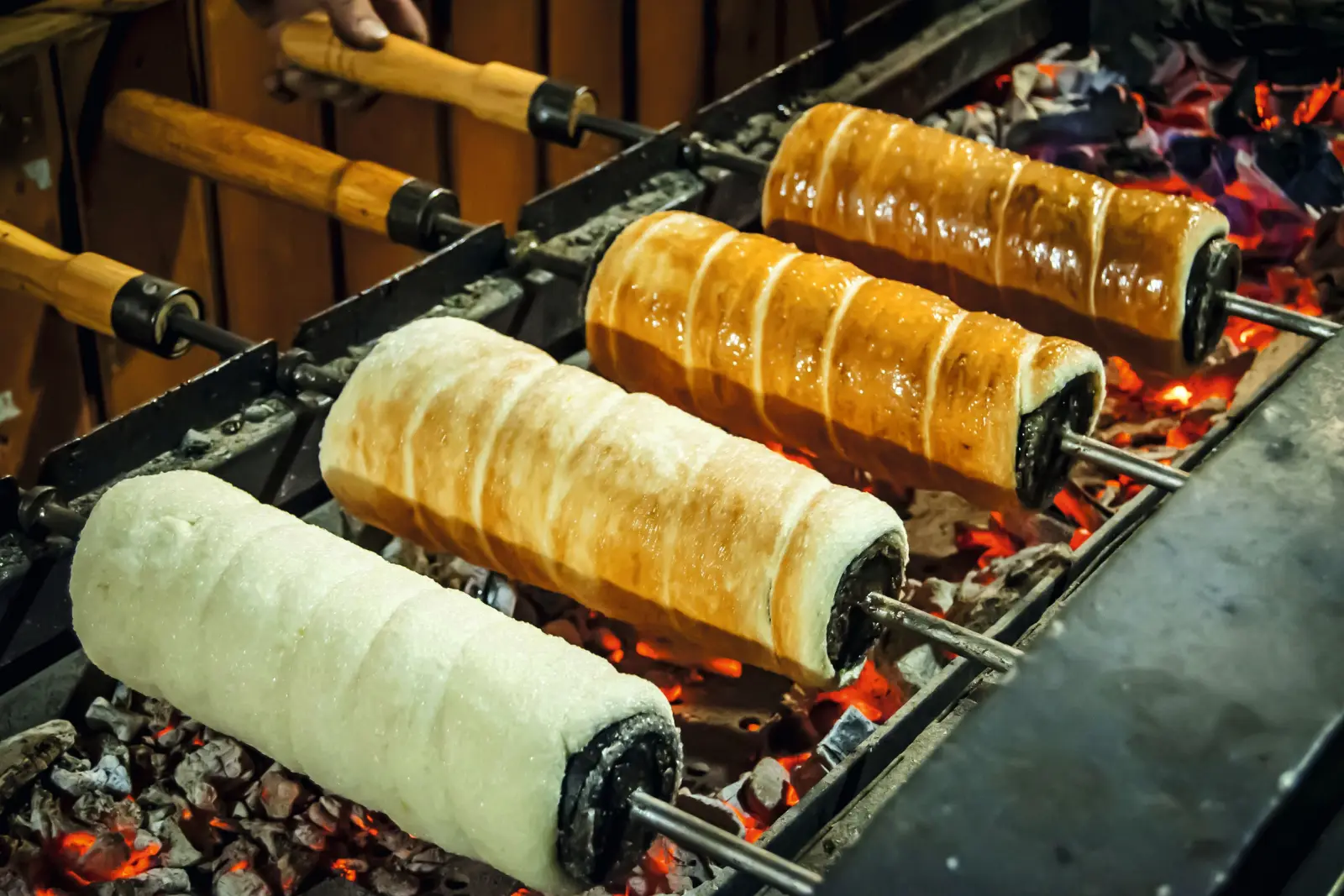Trdelník, dolce tradizionale arrostito su spiedini sopra braci ardenti.