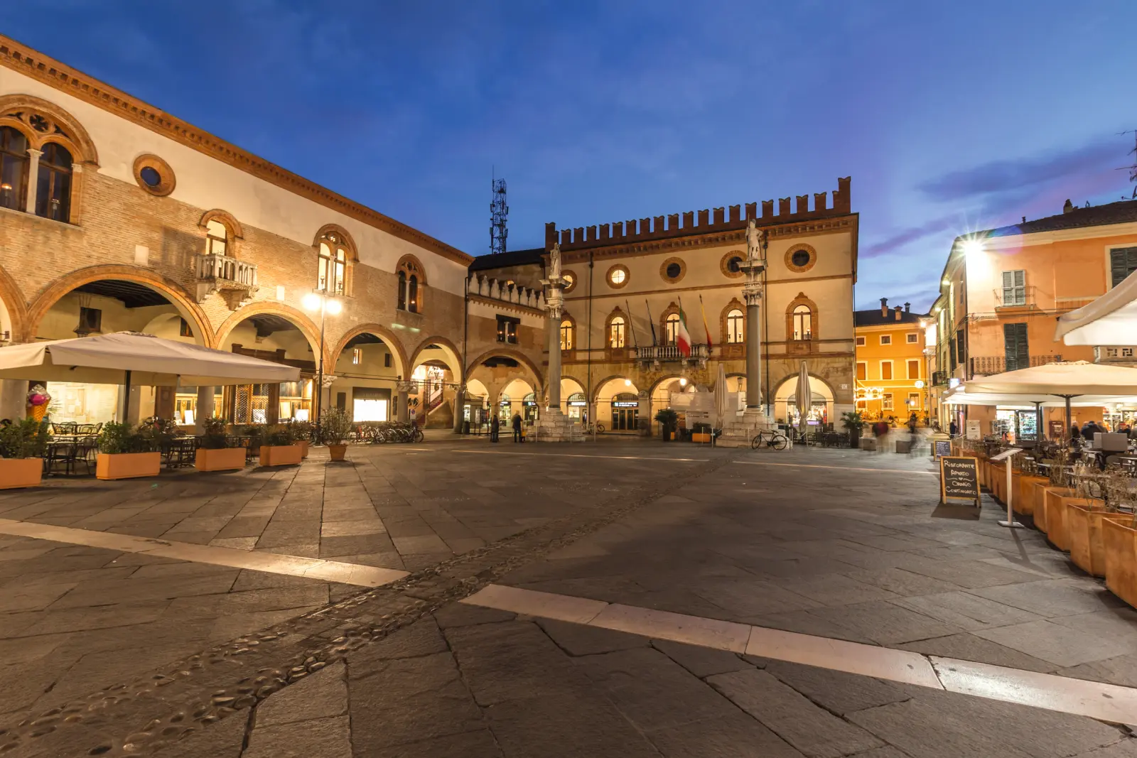 Place italienne au crépuscule, entourée de bâtiments historiques.