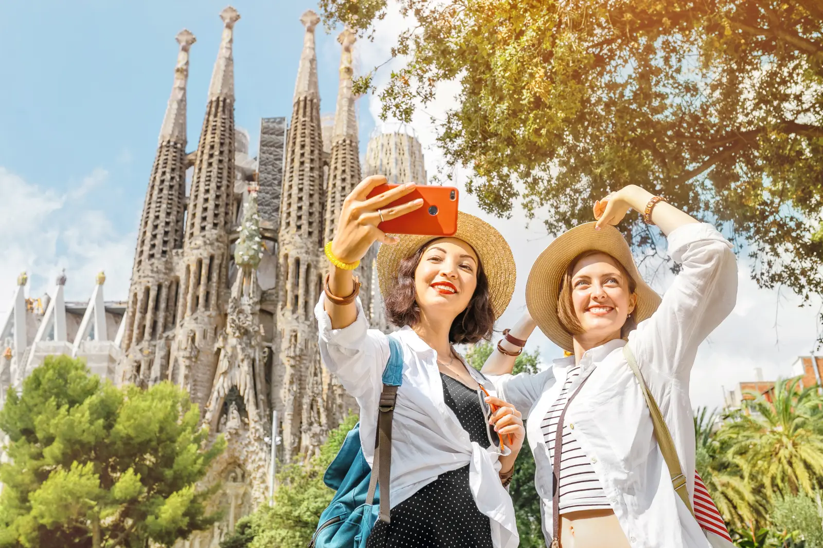 Two people taking a selfie in front of the Sagrada Família in Barcelona.