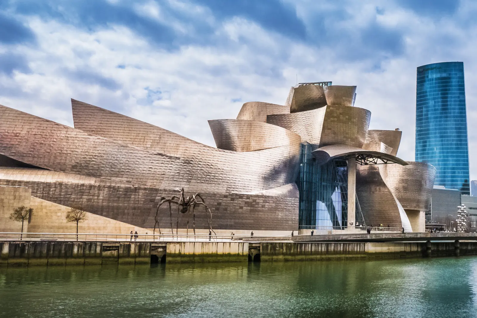 Architettura moderna del Guggenheim Museum di Bilbao con una scultura davanti.