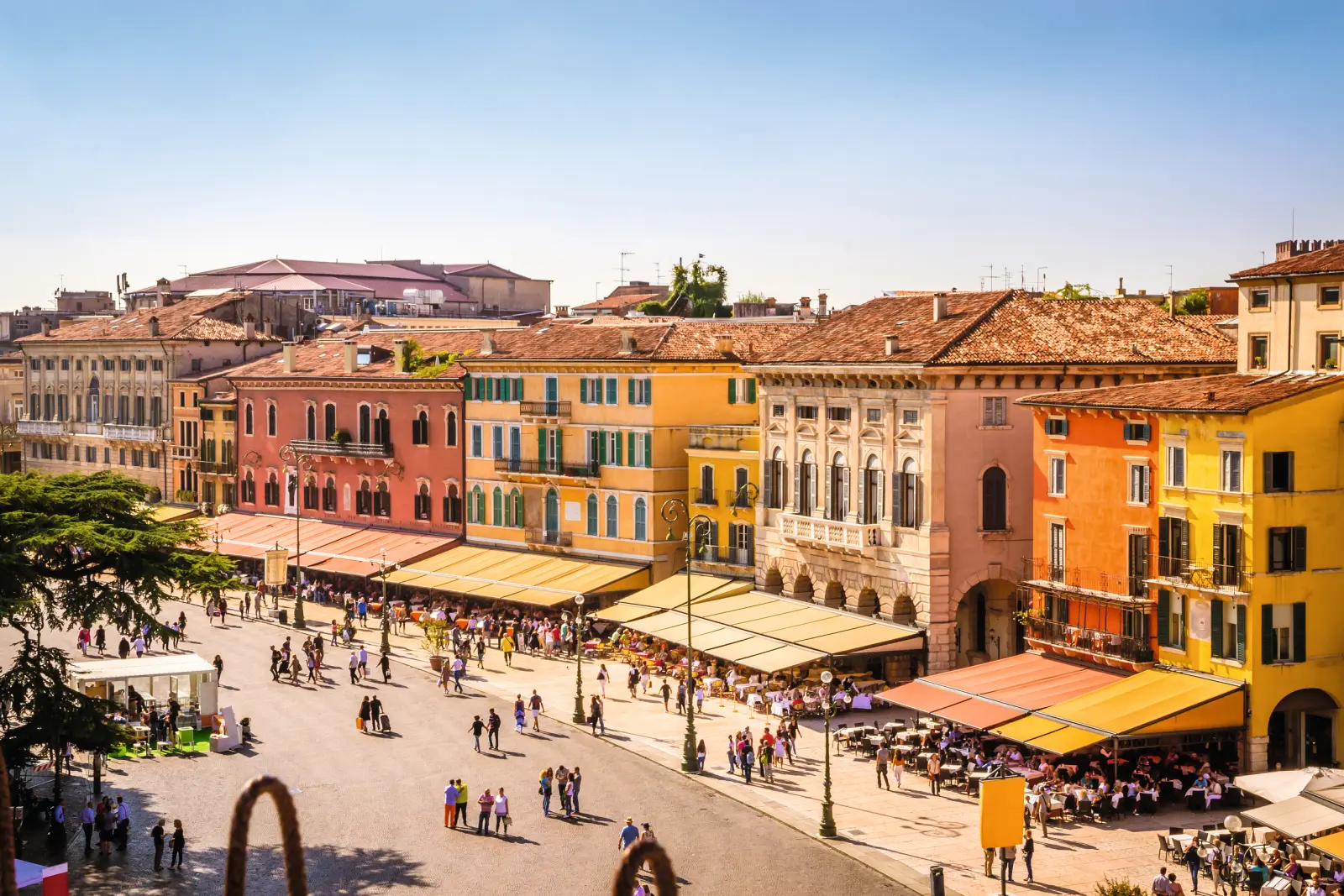Colourful historic buildings on a busy square in sunny weather.