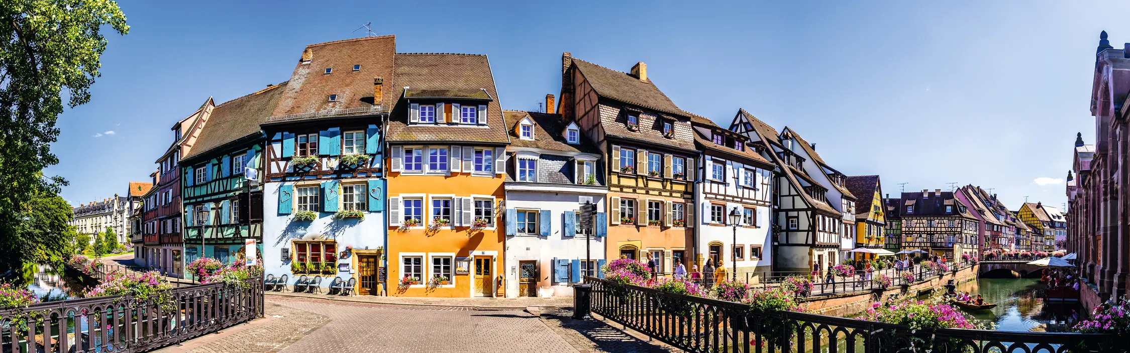 Farbige Fachwerkhäuser an einem Kanal in einer europäischen Altstadt.