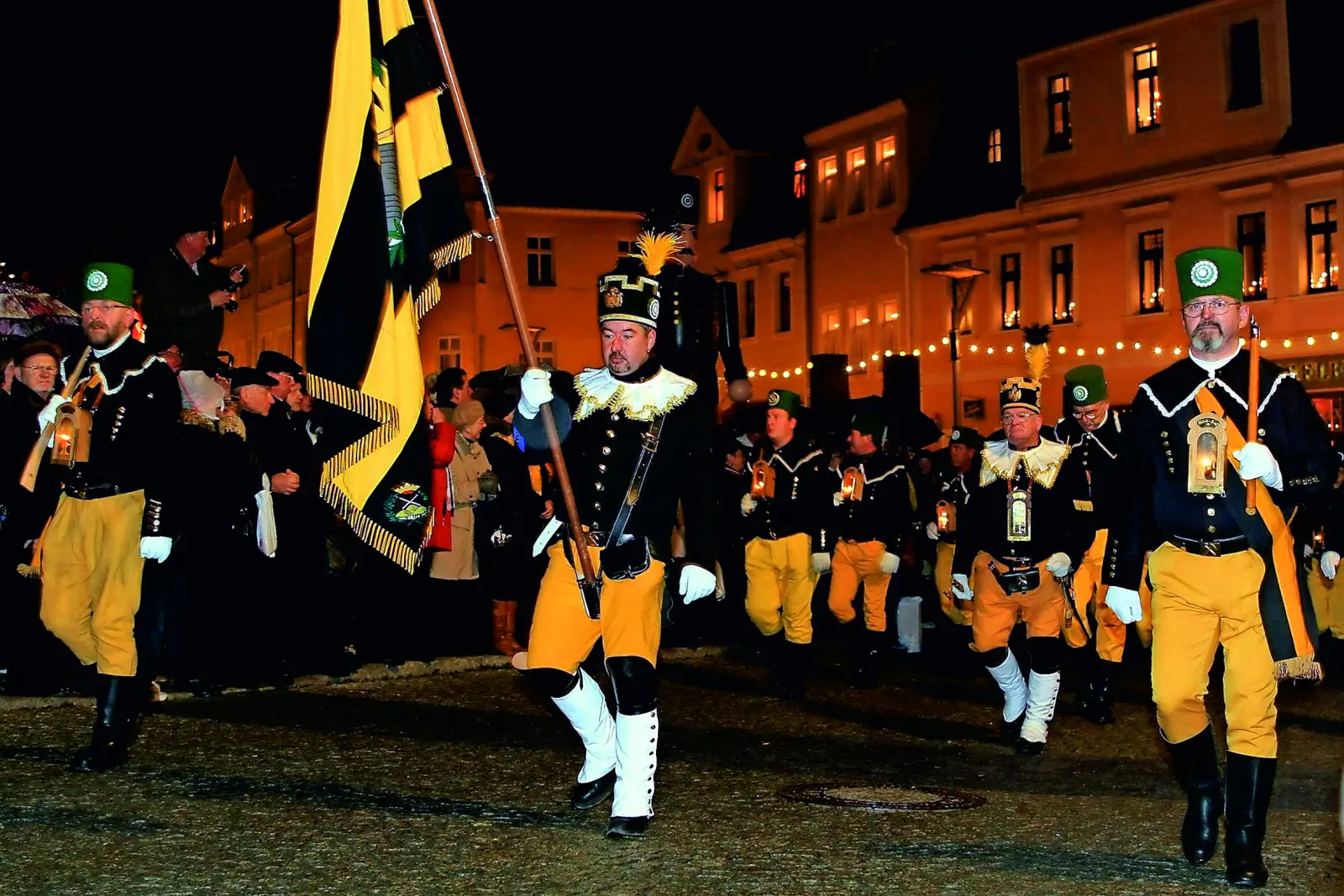Men in traditional miners' costume during a night-time parade in Schneeberg.
