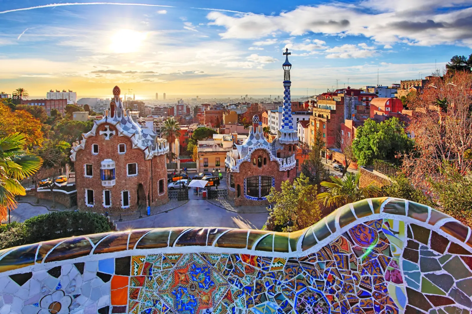 Parco Güell a Barcellona con mosaico colorato in primo piano al tramonto.