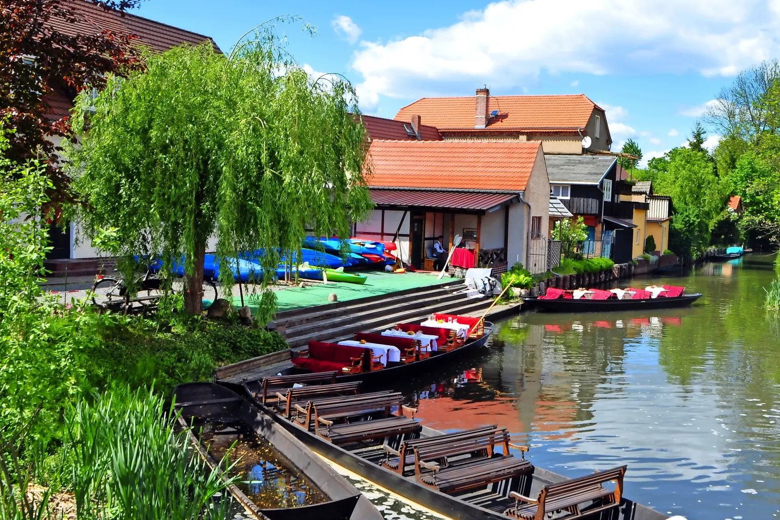 Maisons et bateaux au bord de la rivière par temps ensoleillé.