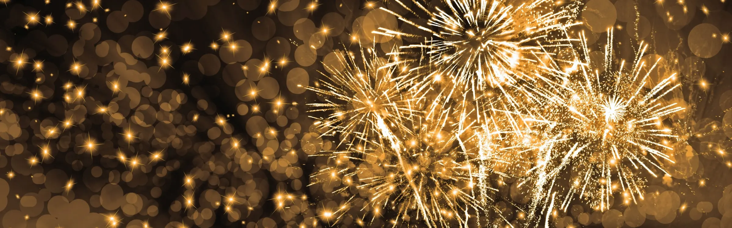 Goldenes Feuerwerk vor dunklem Hintergrund.