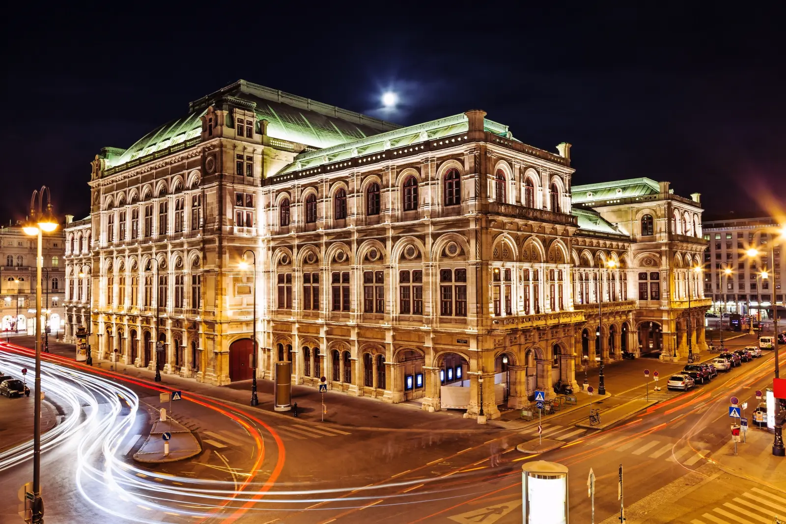 Historic opera house at night with illuminated facades.