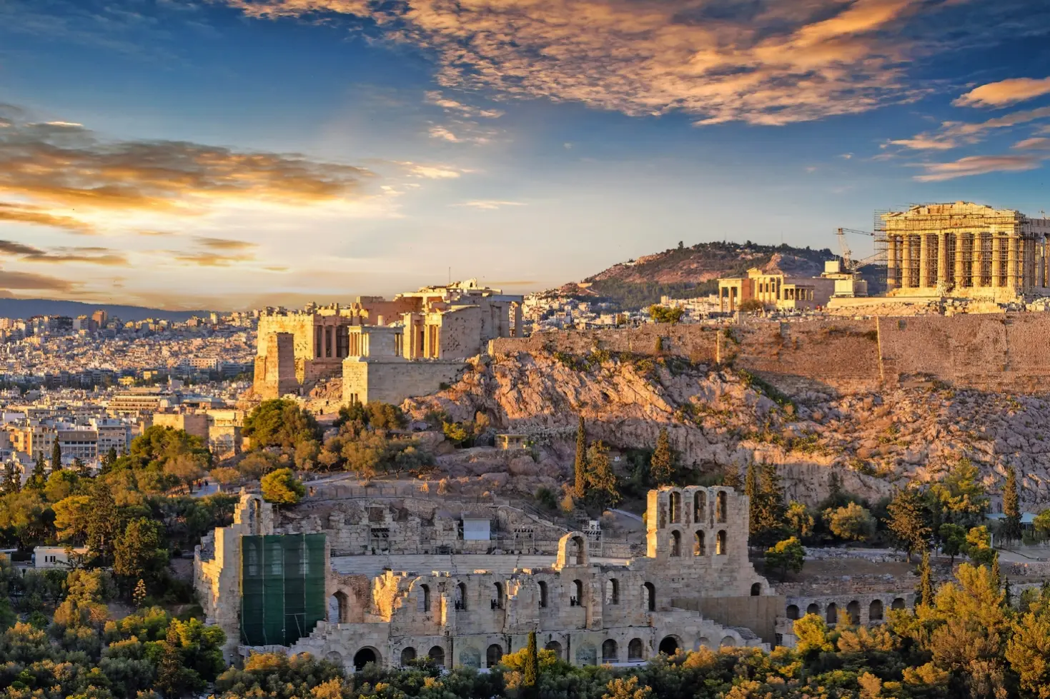 Vista sull'Acropoli di Atene al tramonto, con cielo e città circostante.