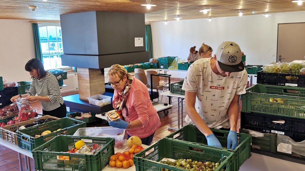 Des bénévoles trient et emballent des denrées alimentaires dans des sacs.
