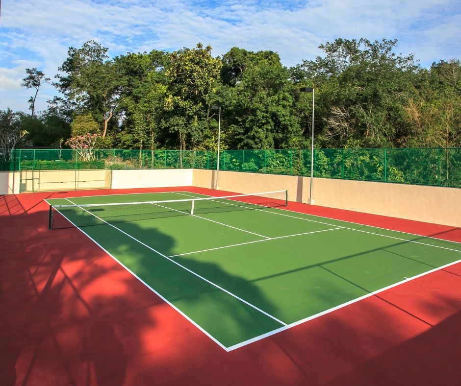 How does regular cleaning enhance tennis court safety?