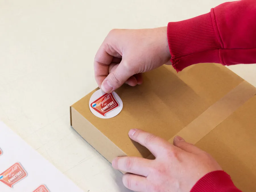 Etikette «Hergestellt in Ennetsee» wird auf Paket geklebt